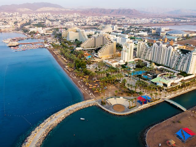 Aerial view of a coastal city in Israel featuring luxury hotels, beautiful beaches, and scenic waterfront, showcasing an ideal destination for medical tourism and recovery.